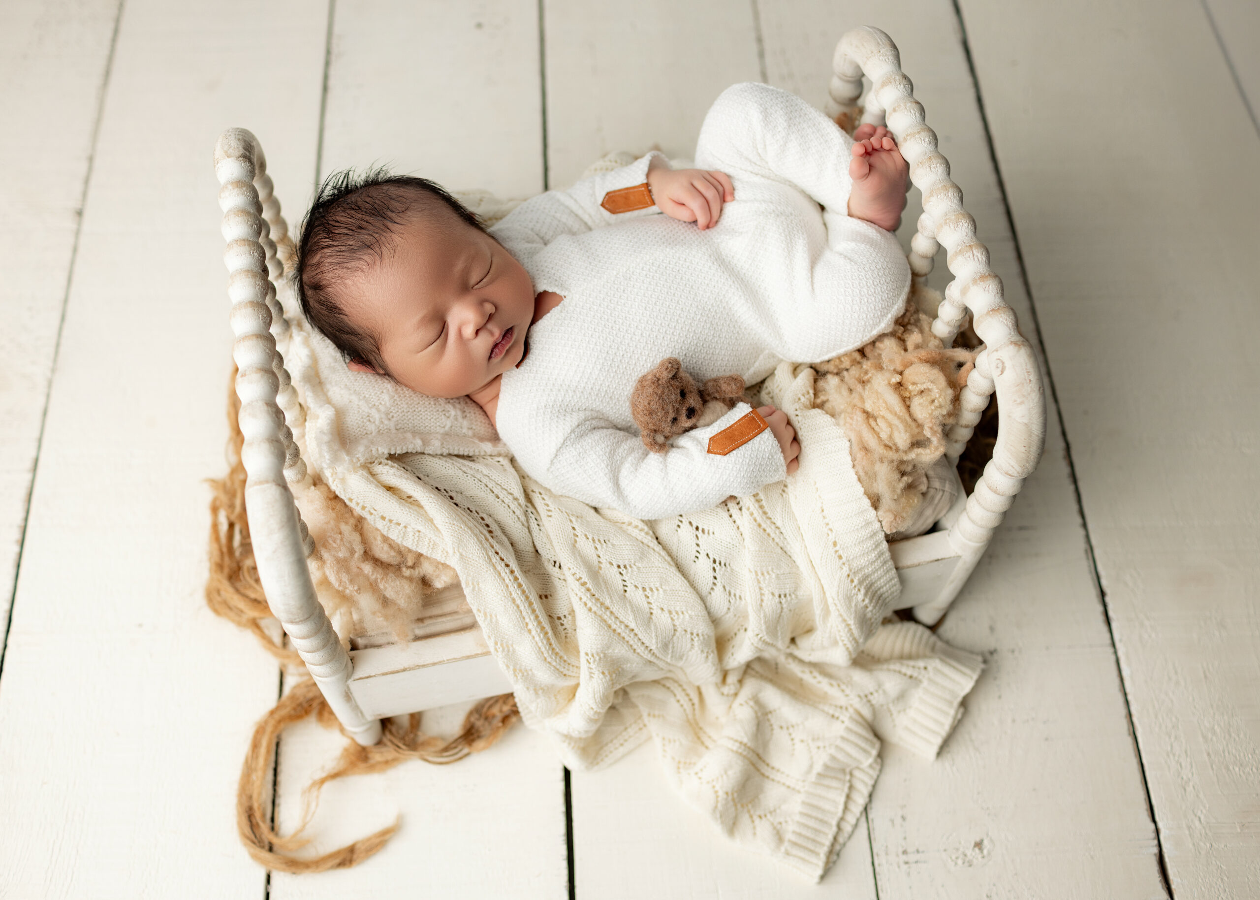 baby boy with teddy in white wooden bed
